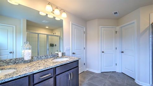 Bathroom with double sinks, glass door shower