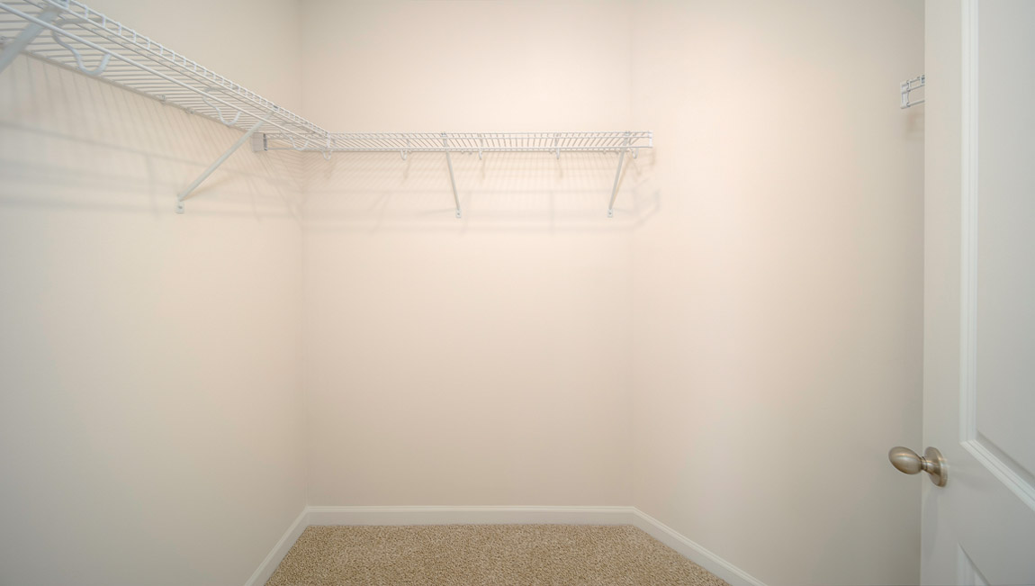 Primary bedroom walk in closet with shelving