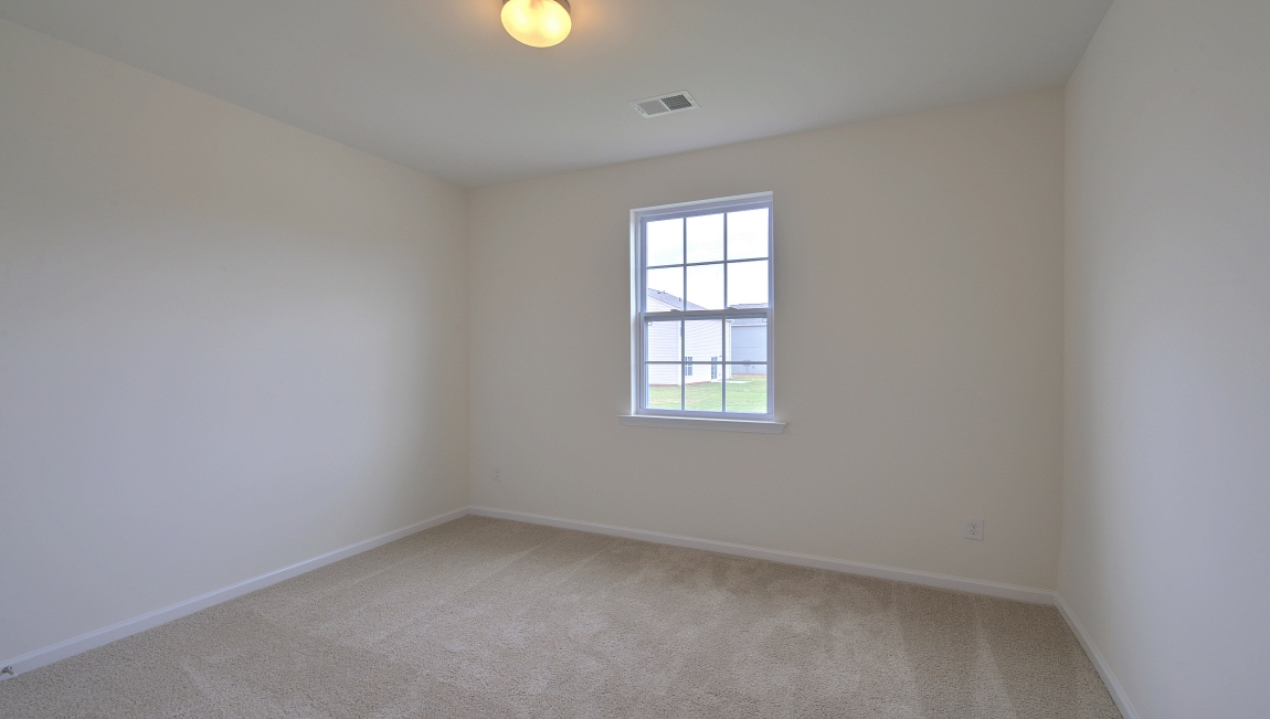 Carpeted bedroom with small window