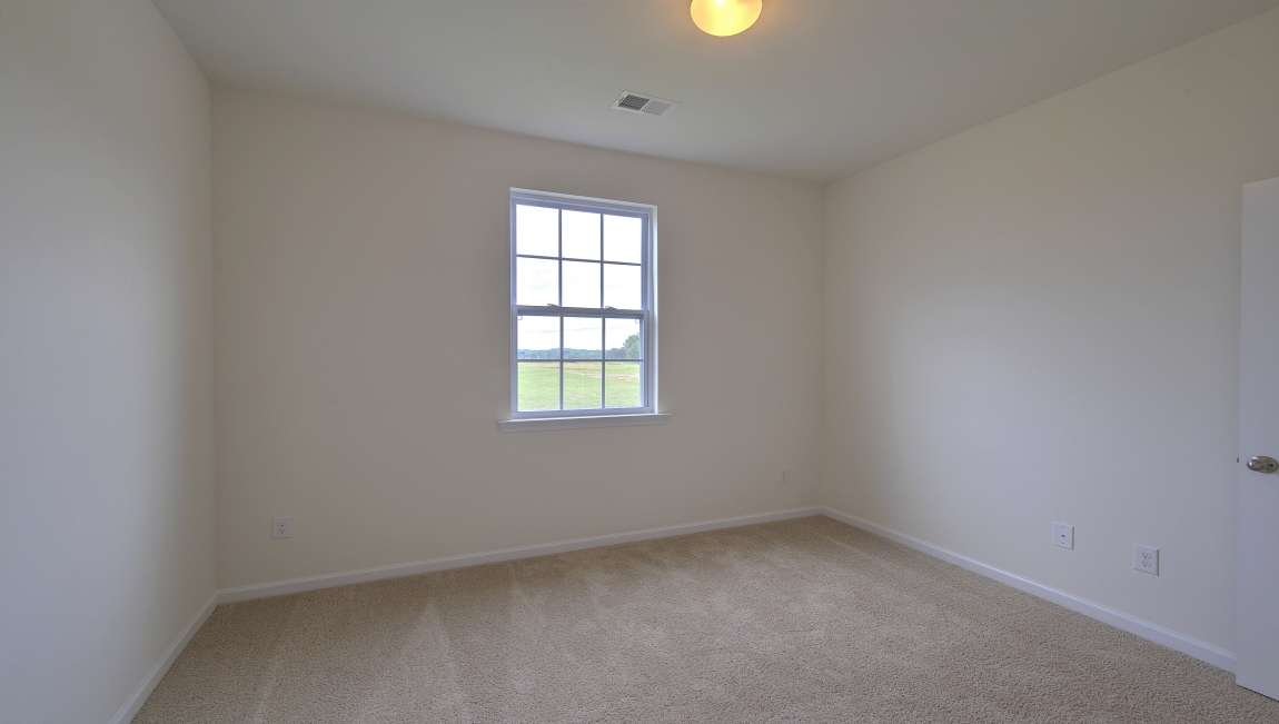 Carpeted bedroom with small window