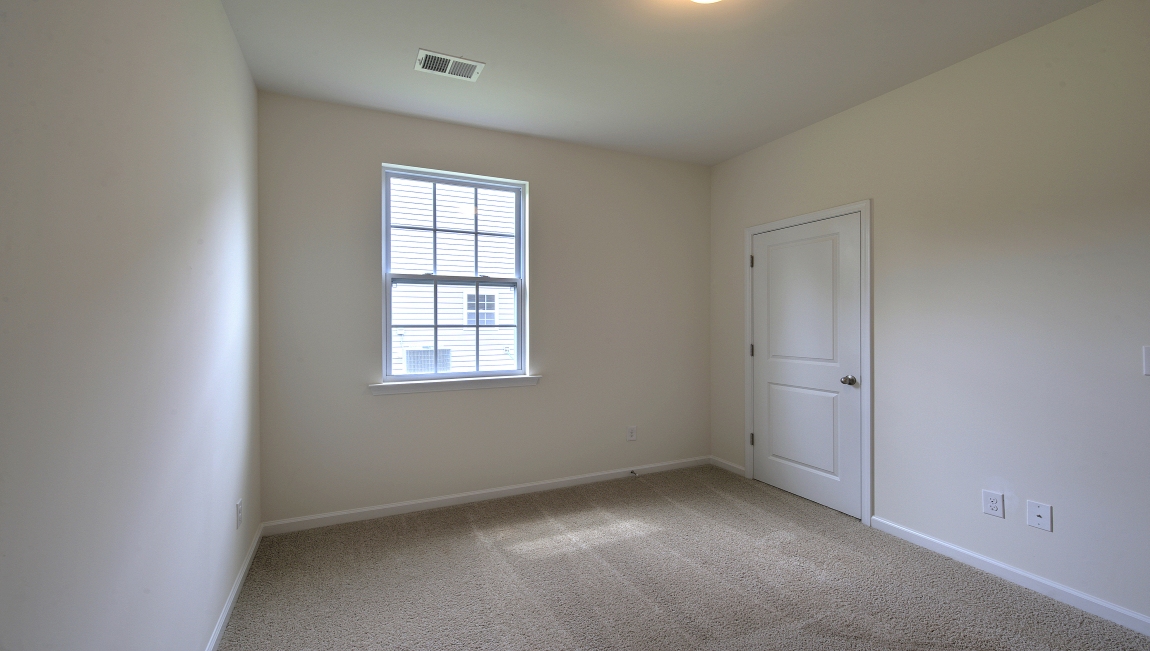 Carpeted bedroom with small window