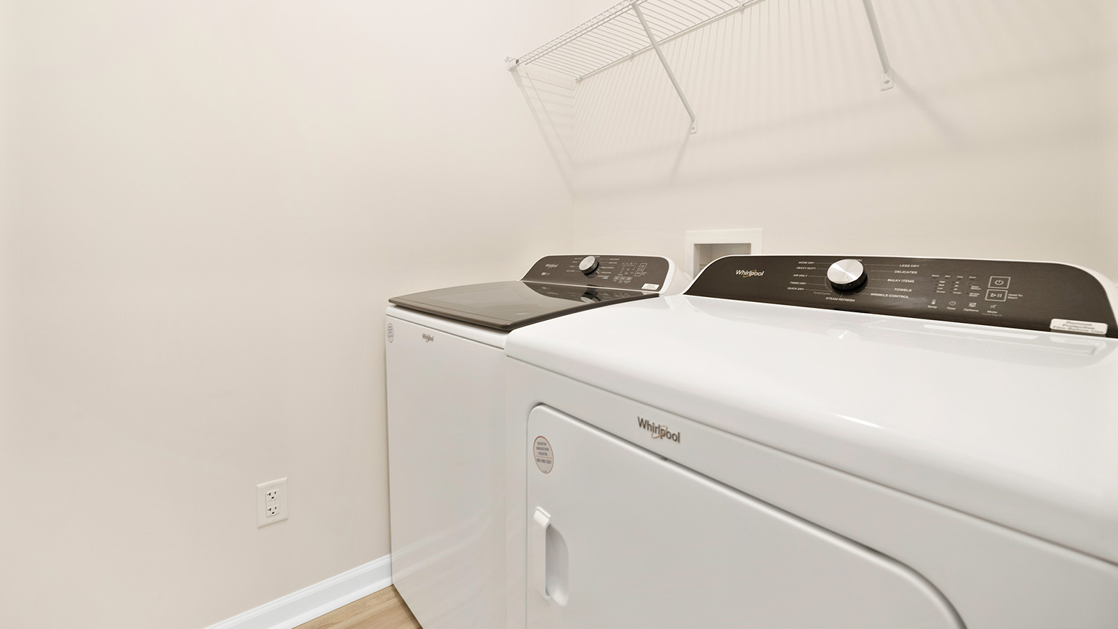 Laundry room with built in storage and hanging racks above machine space