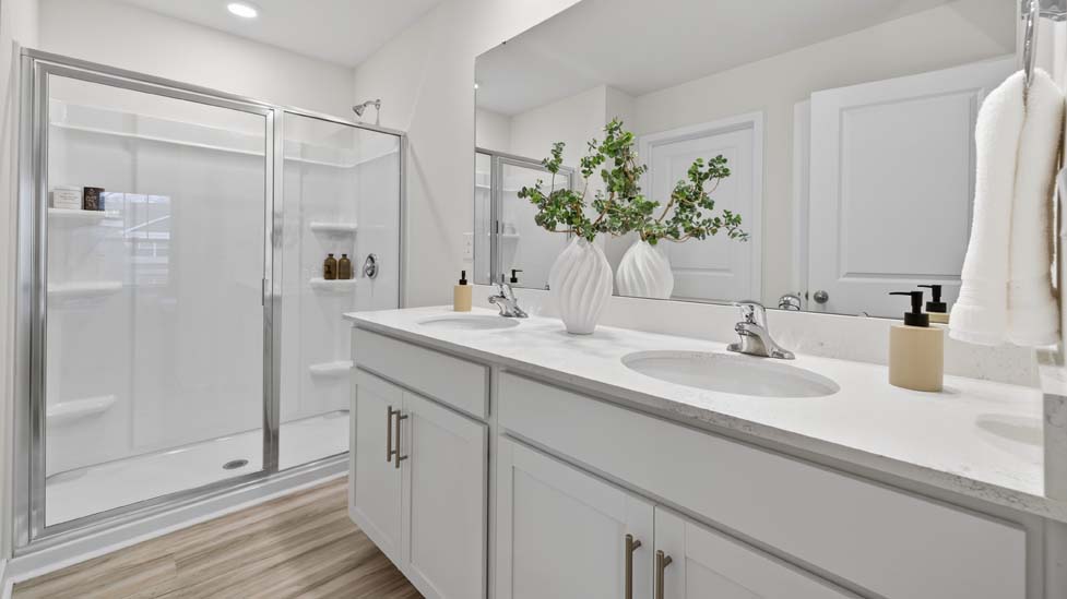 Primary bathroom with double vanity and walk in shower
