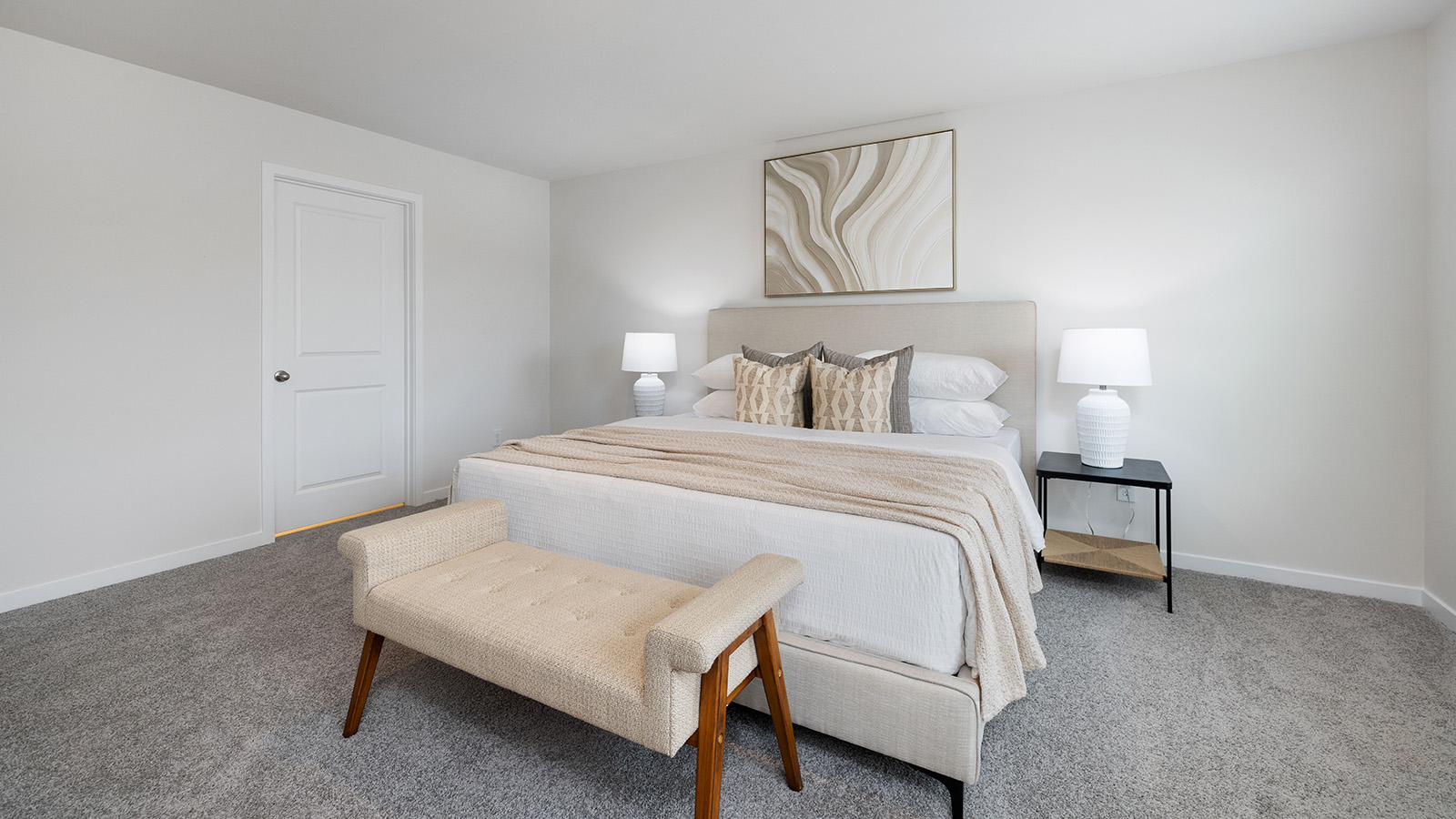 Primary bedroom with wood floors, two large windows