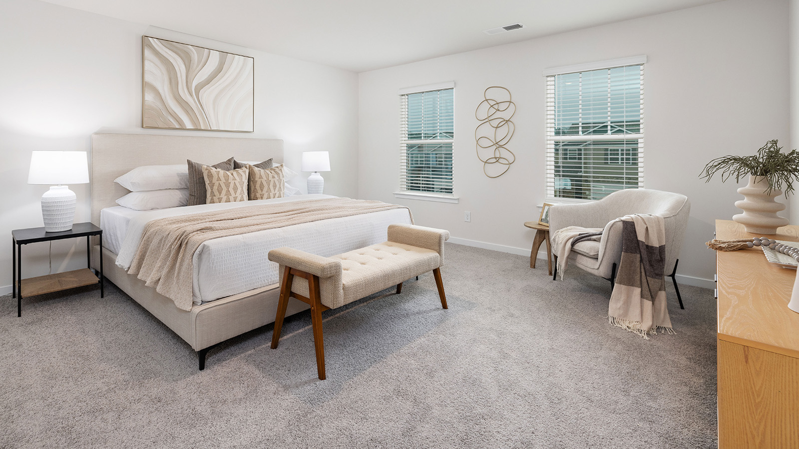 Primary bedroom with wood floors, two large windows