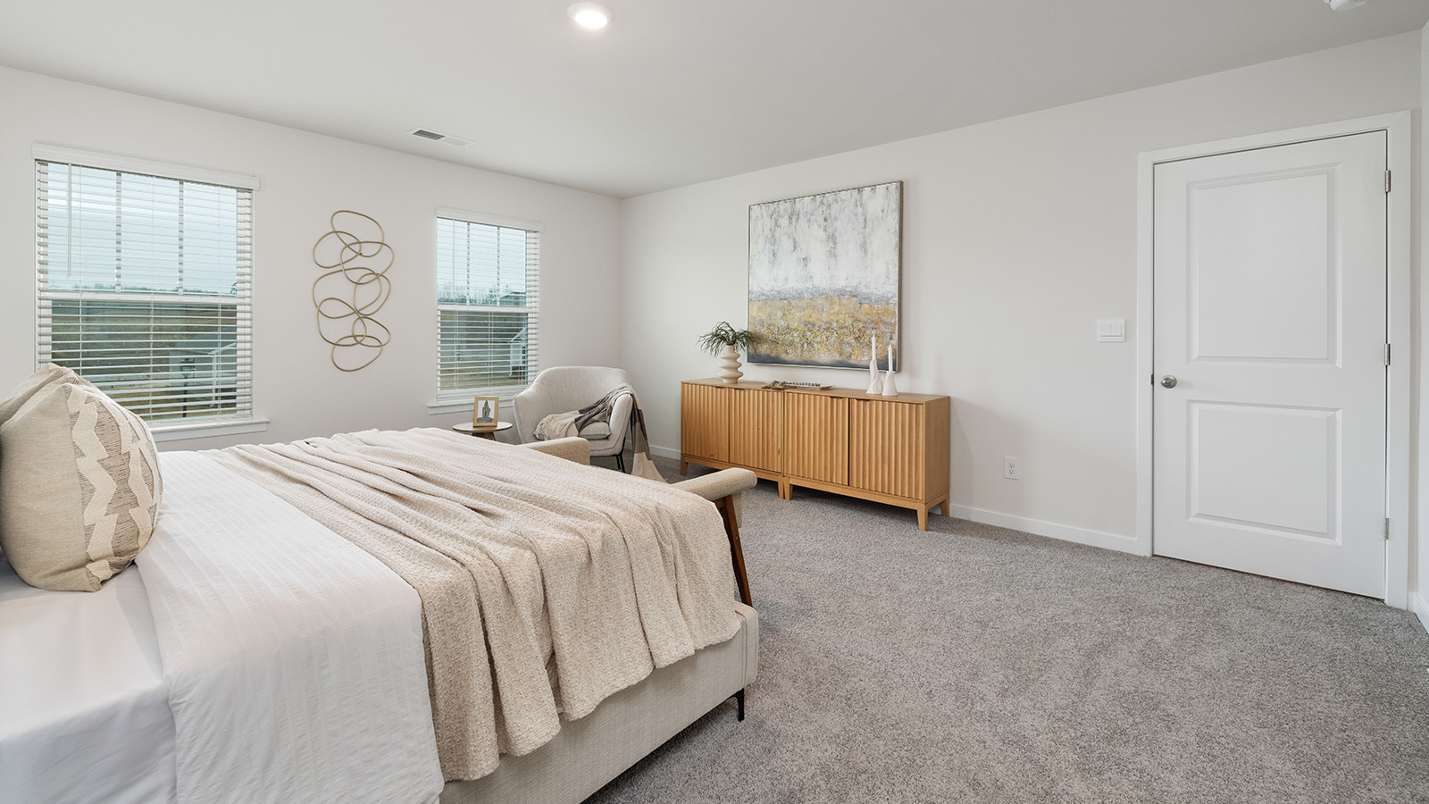 Primary bedroom with wood floors, two large windows