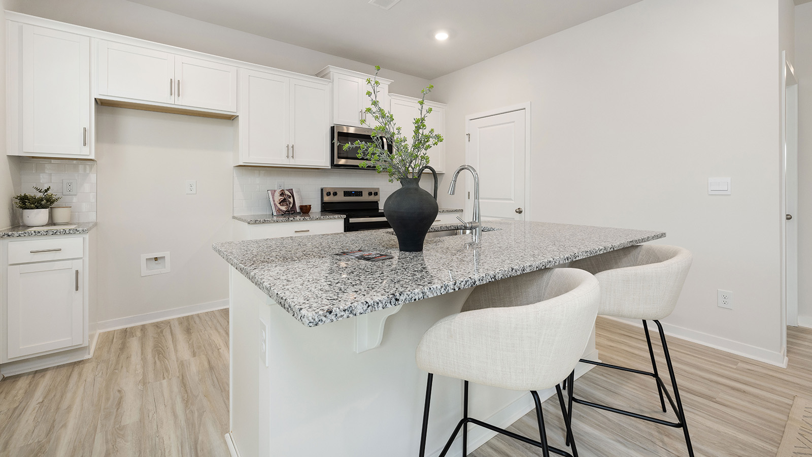 Kitchen with island, white cabinets and wood floors