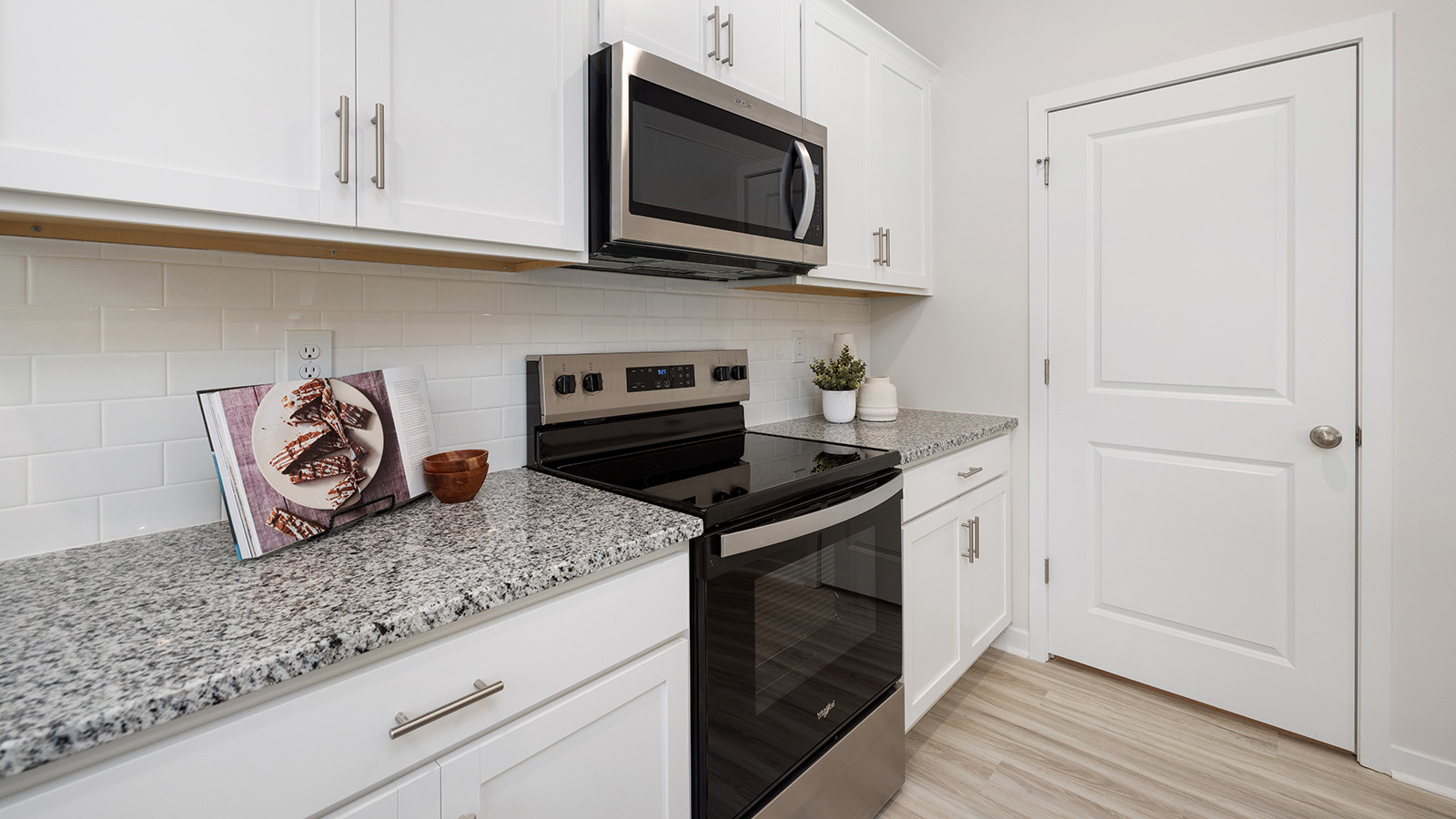 Kitchen with island, white cabinets and wood floors