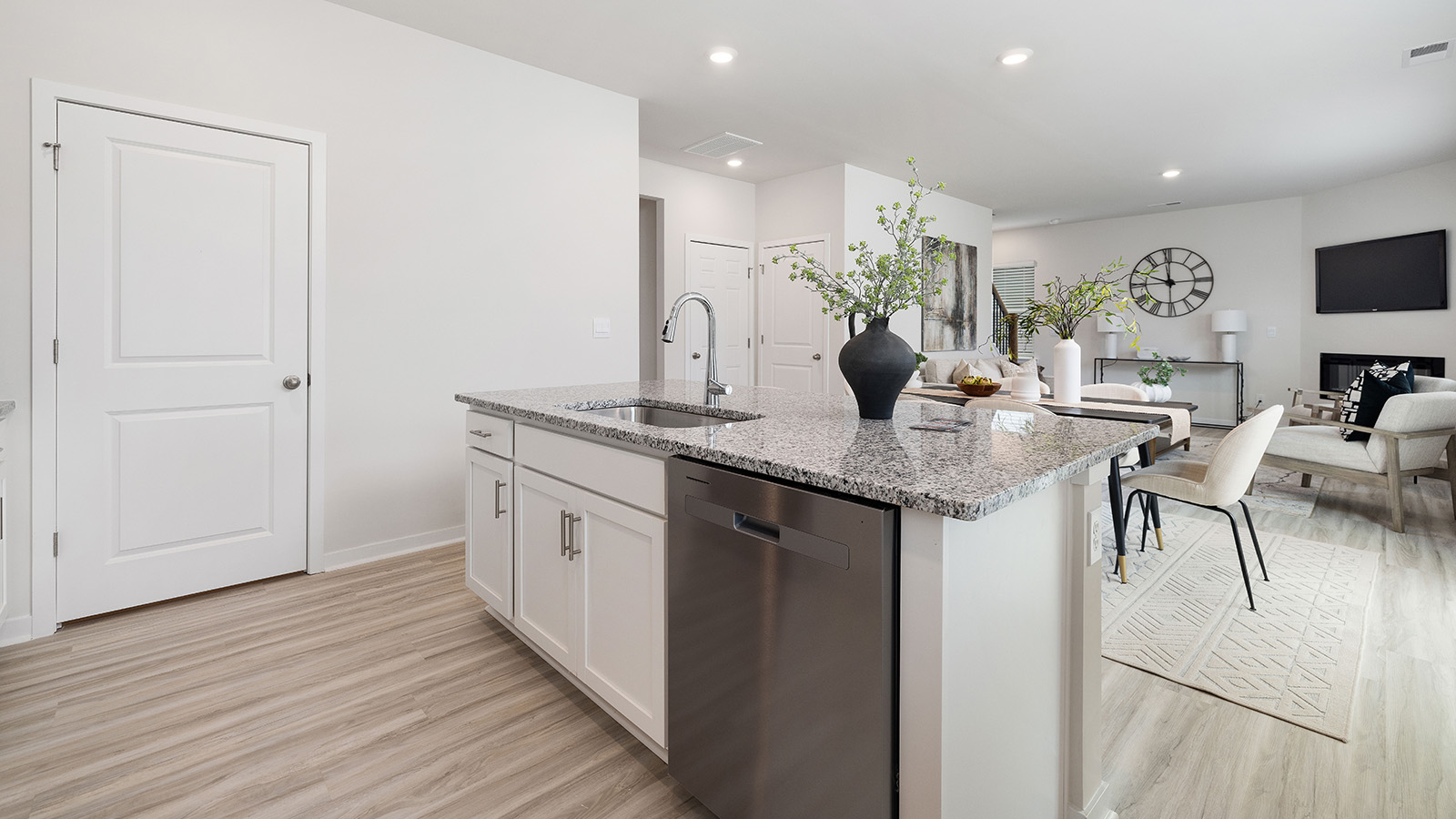 Kitchen with island, white cabinets and wood floors