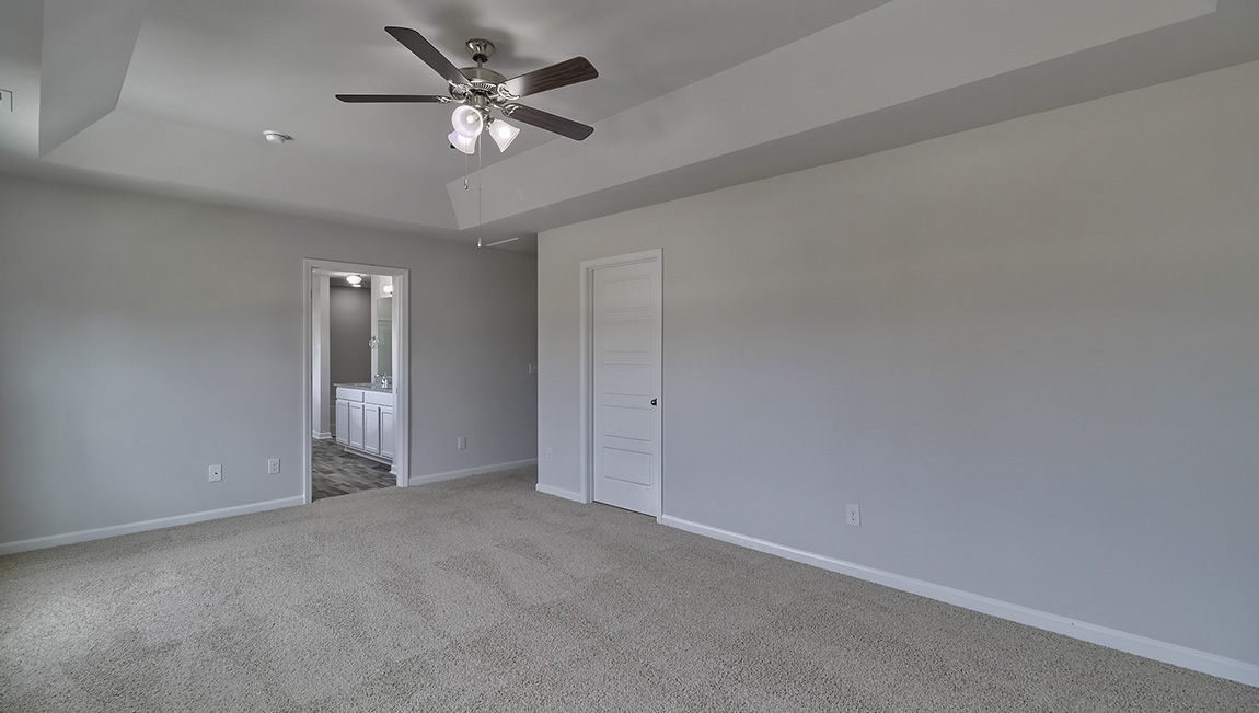 Primary bedroom with carpet, ceiling fan and large windows