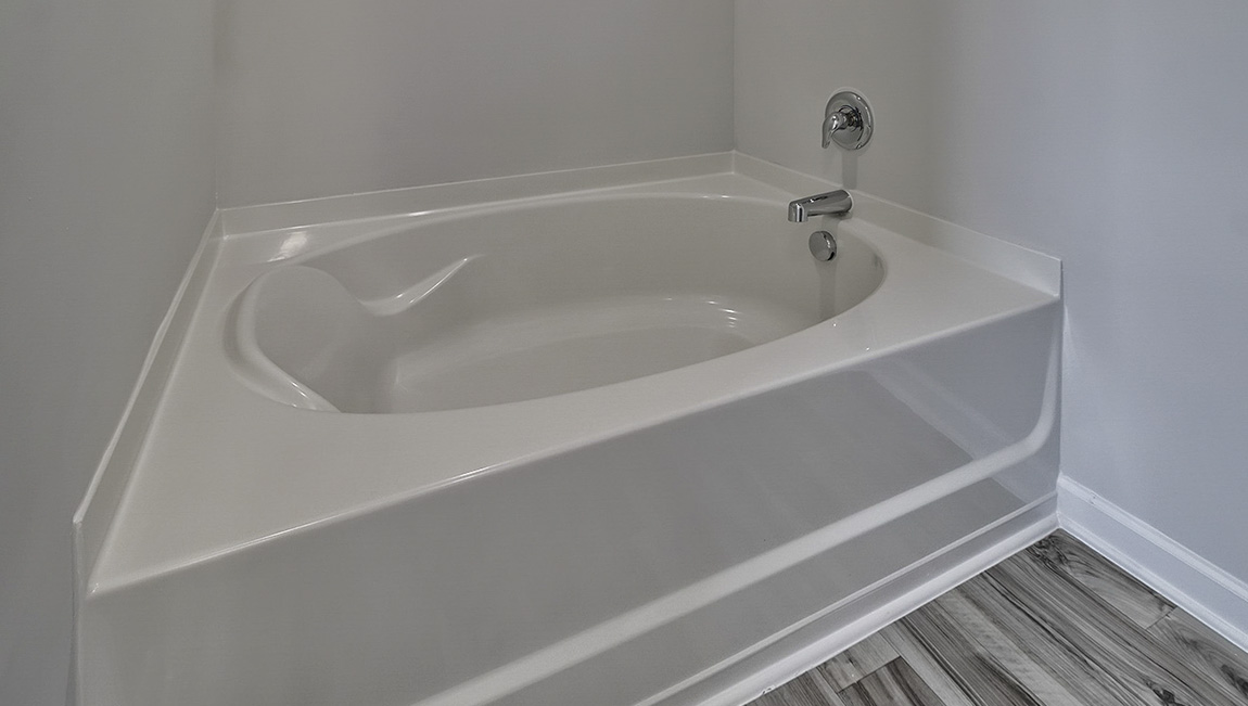 Primary bathroom with standing glass door shower, large bathtub, and double sink vanity