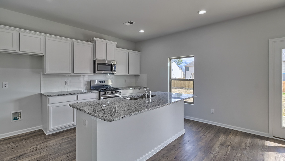 Kitchen and island with white cabinets and stainless steel appliances