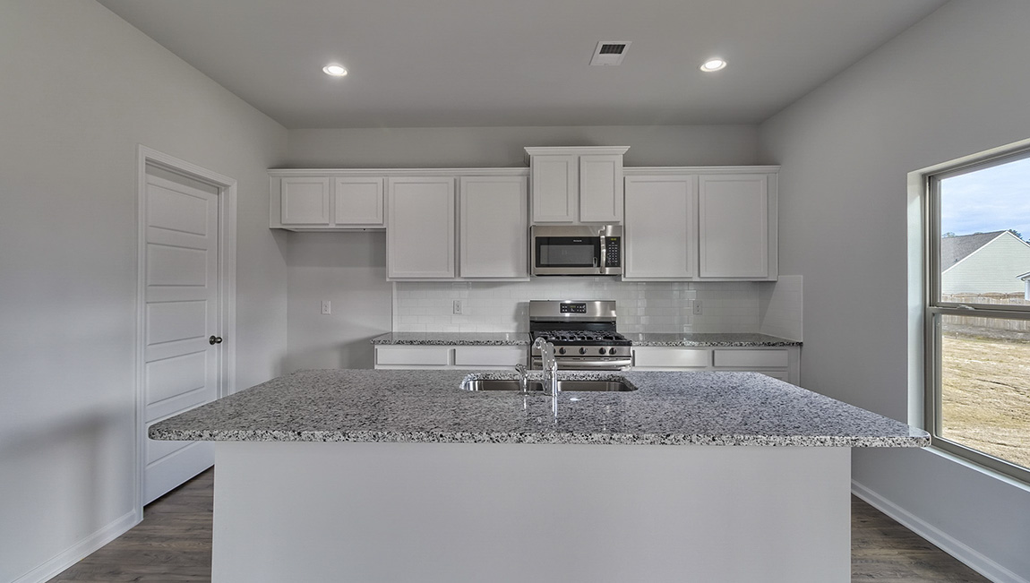 Kitchen and island with white cabinets and stainless steel appliances