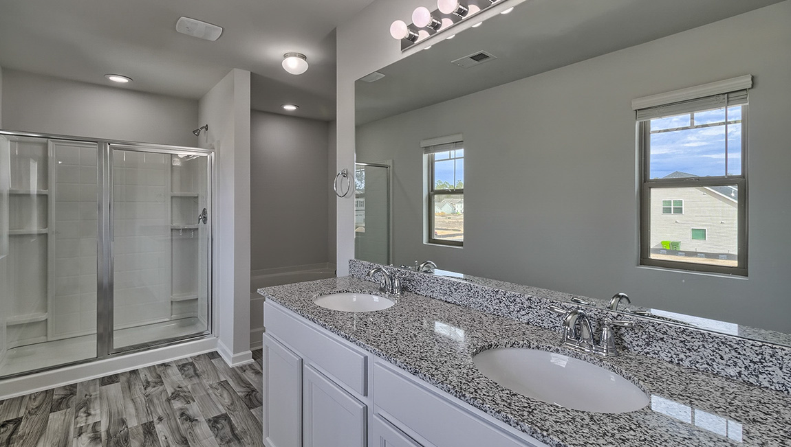 Primary bathroom with standing glass door shower, large bathtub, and double sink vanity