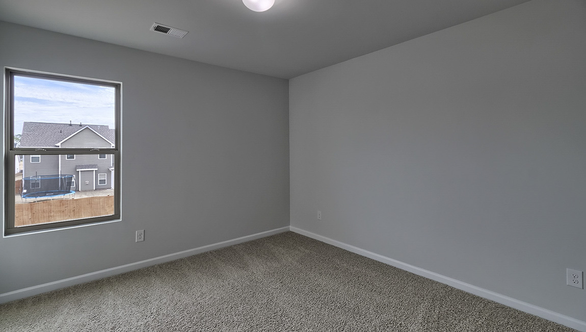 Carpeted bedroom with large window