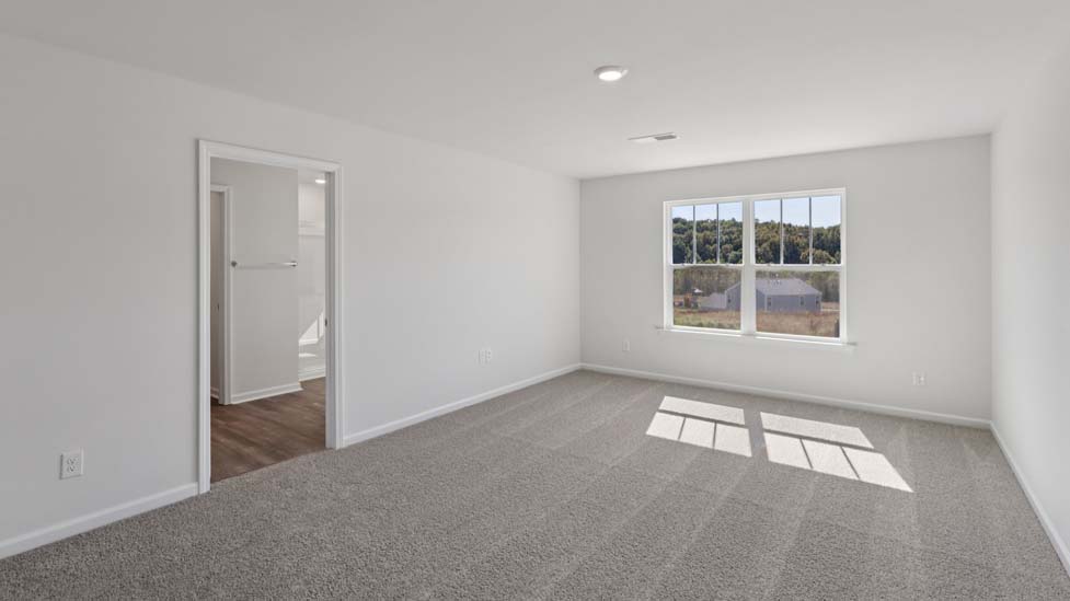 Primary carpeted bedroom with windows