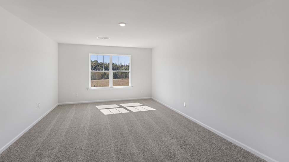 Primary carpeted bedroom with windows