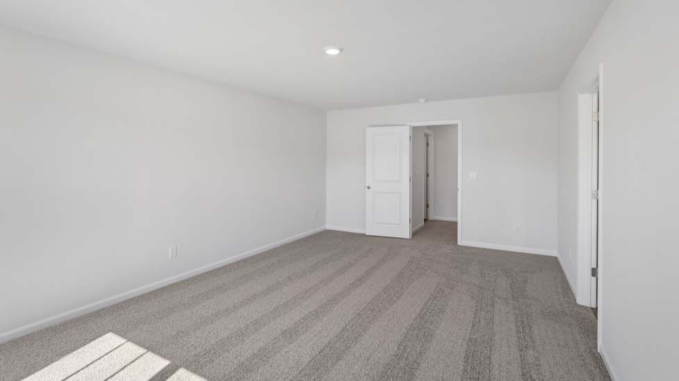Primary carpeted bedroom with windows