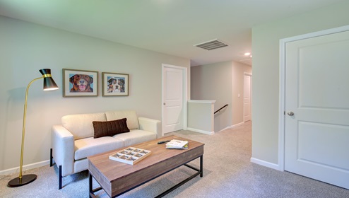 Carpeted loft space with large window