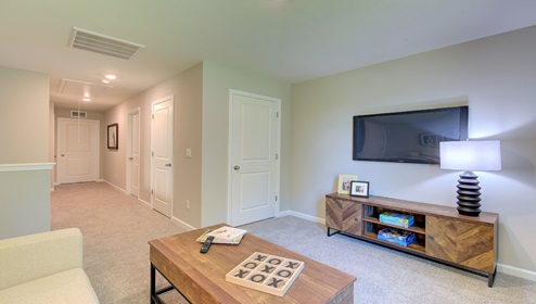 Carpeted loft space with large window