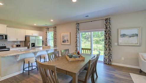 Breakfast area beside kitchen and living room with sliding glass back door