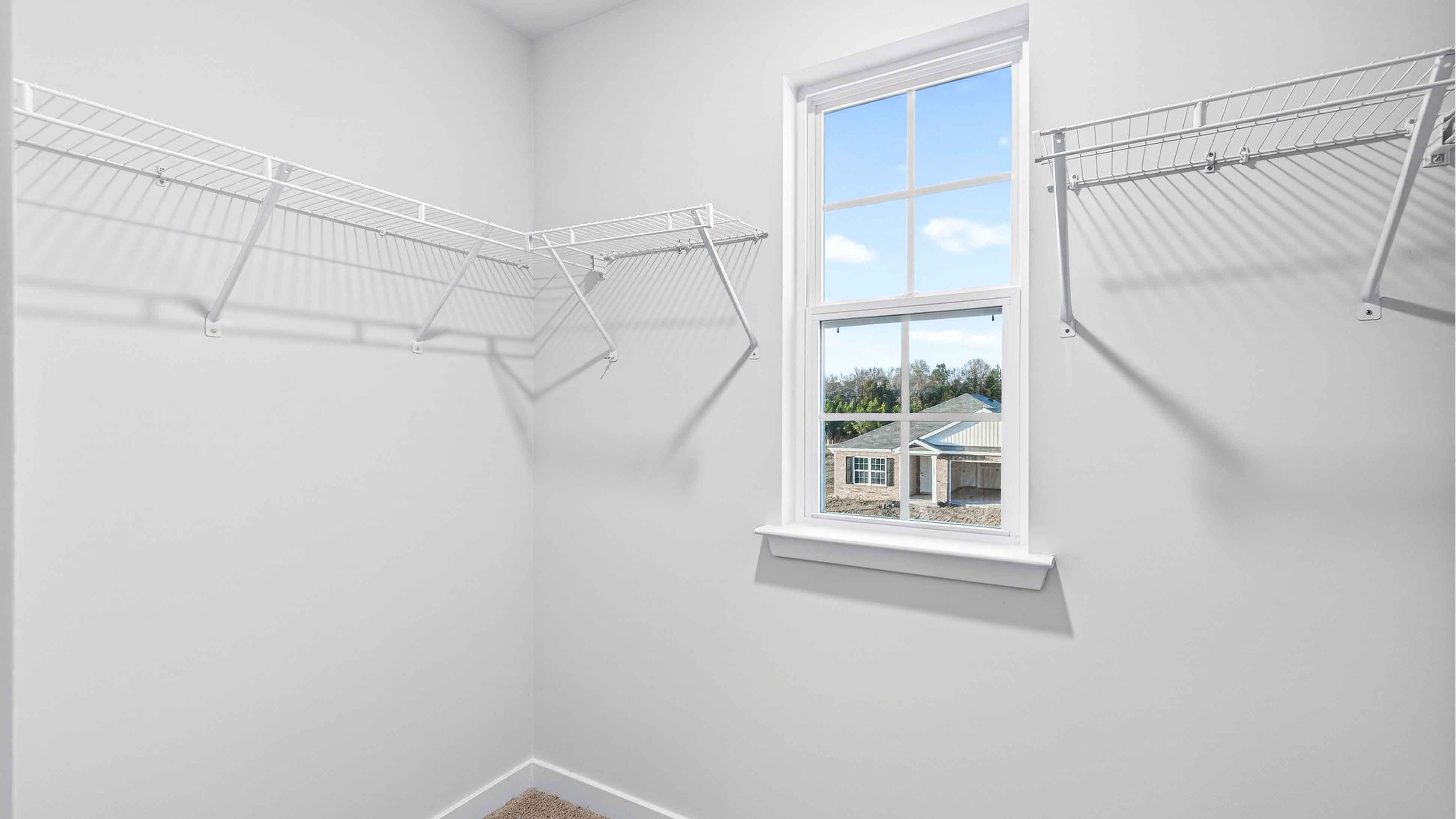 Primary closet with window and shelving
