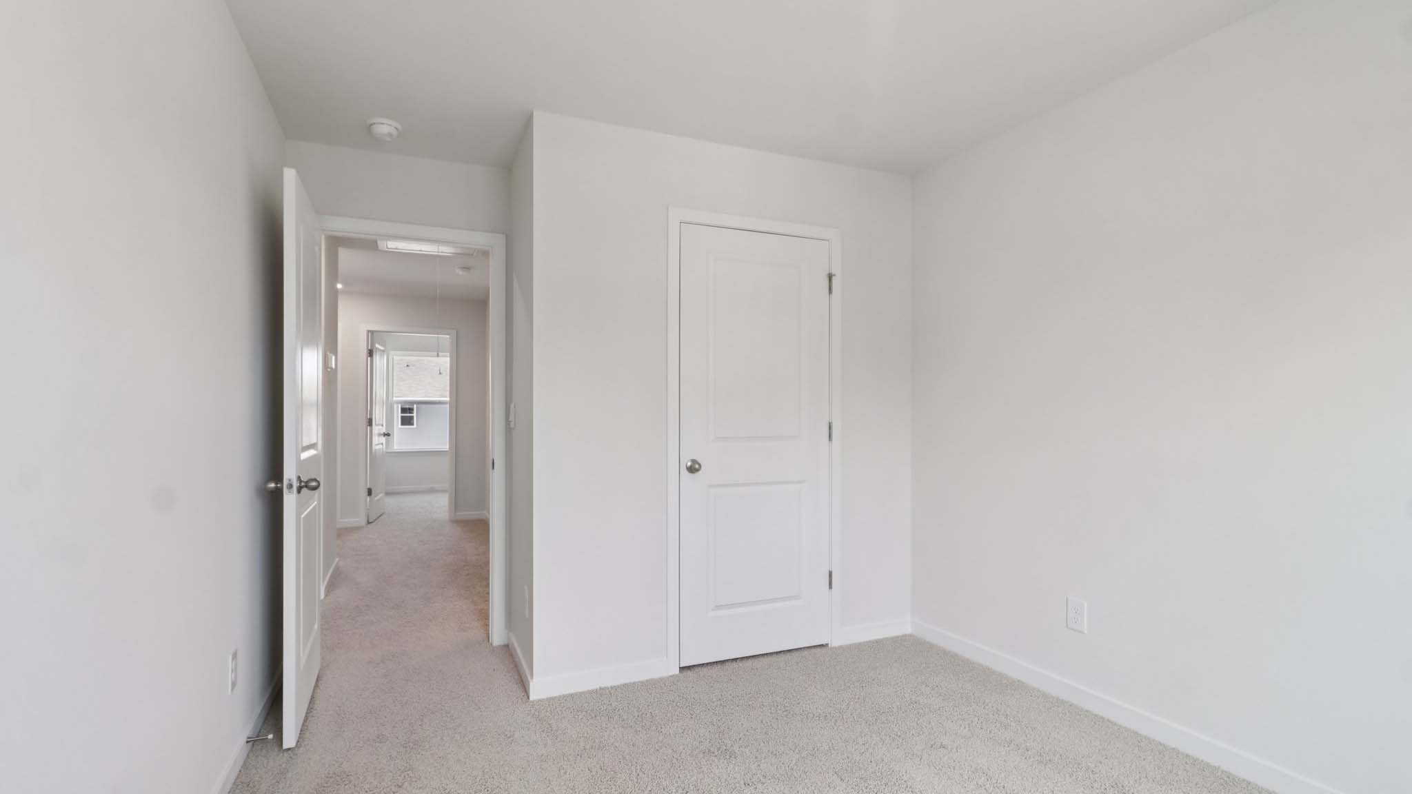Carpeted bedroom with view of hallway