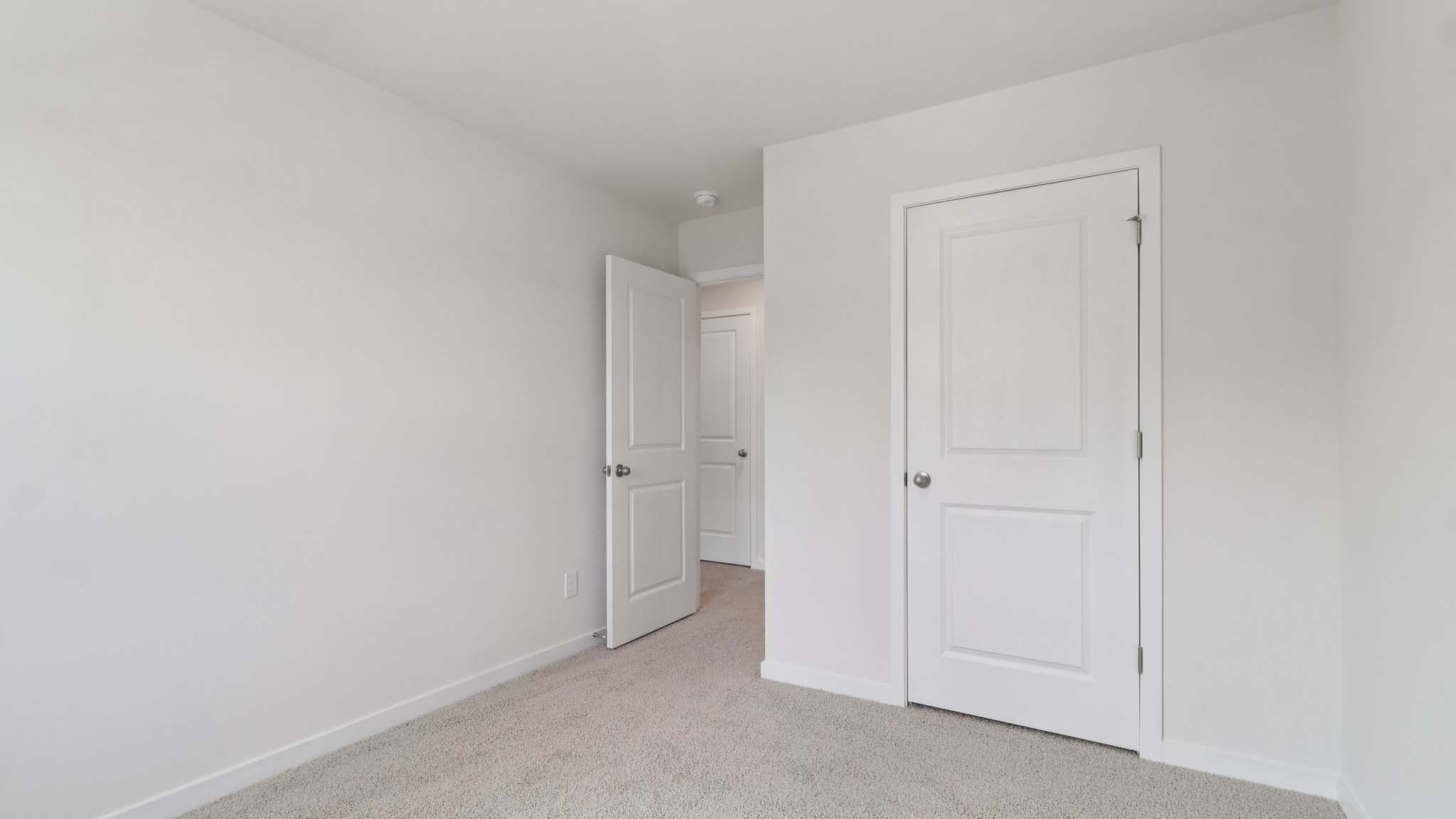 Carpeted bedroom with view of hallway