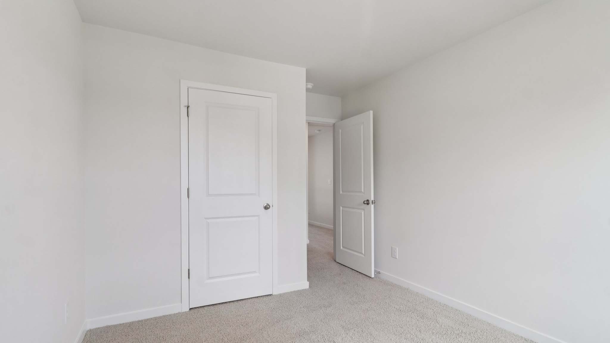 Carpeted bedroom with view of hallway