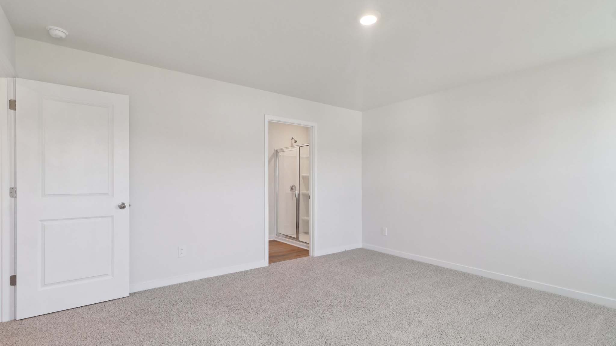 Carpeted primary bedroom with closet
