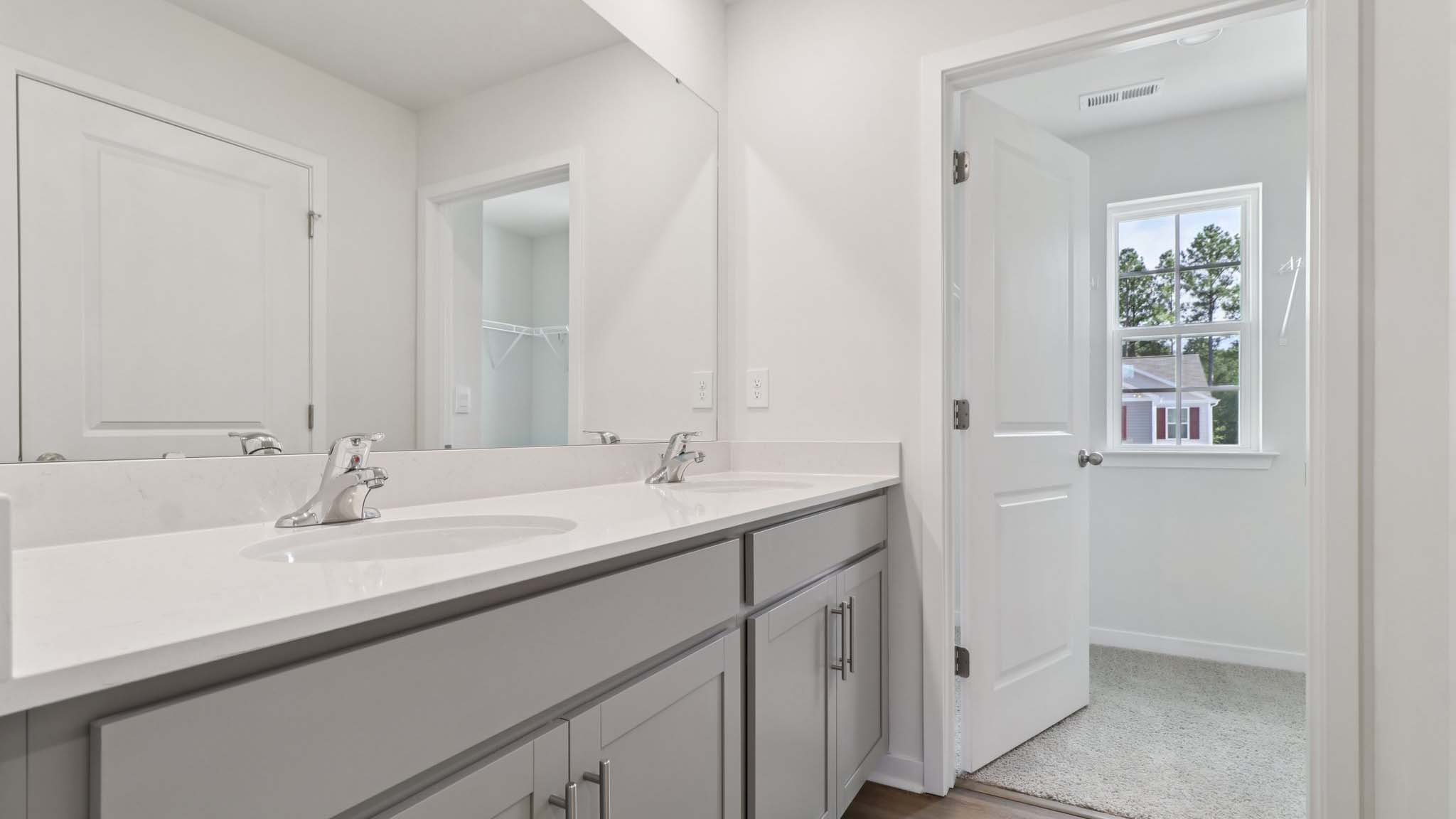 Primary bathroom with window and dual vanity