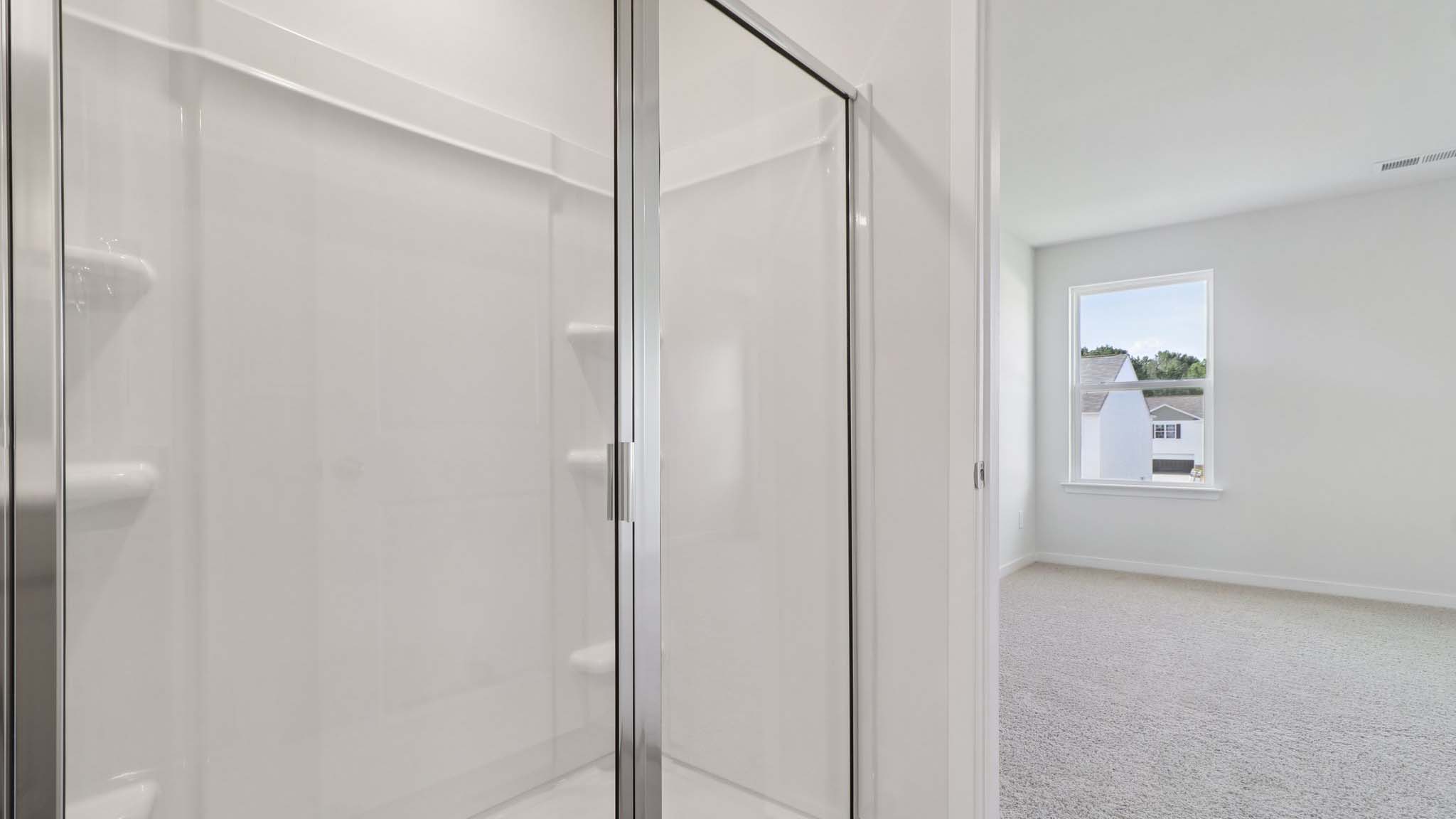 Primary bathroom with walk in shower and window