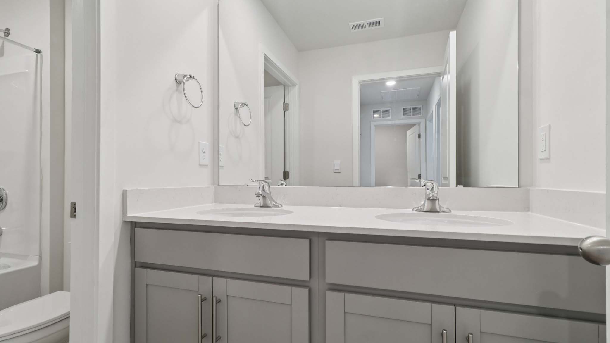 Primary bathroom with dual vanity and mirror