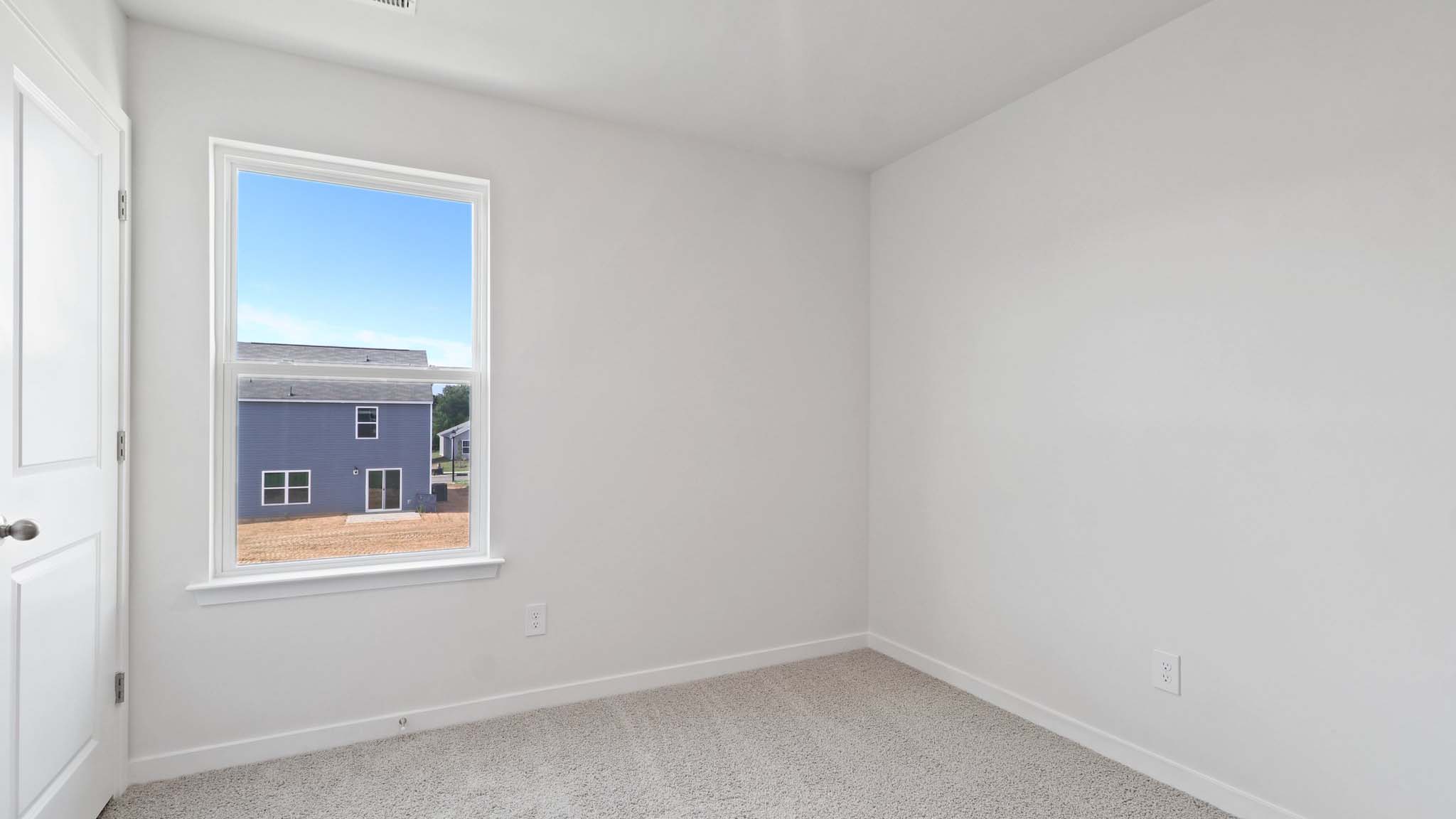 Carpeted bedroom with large window