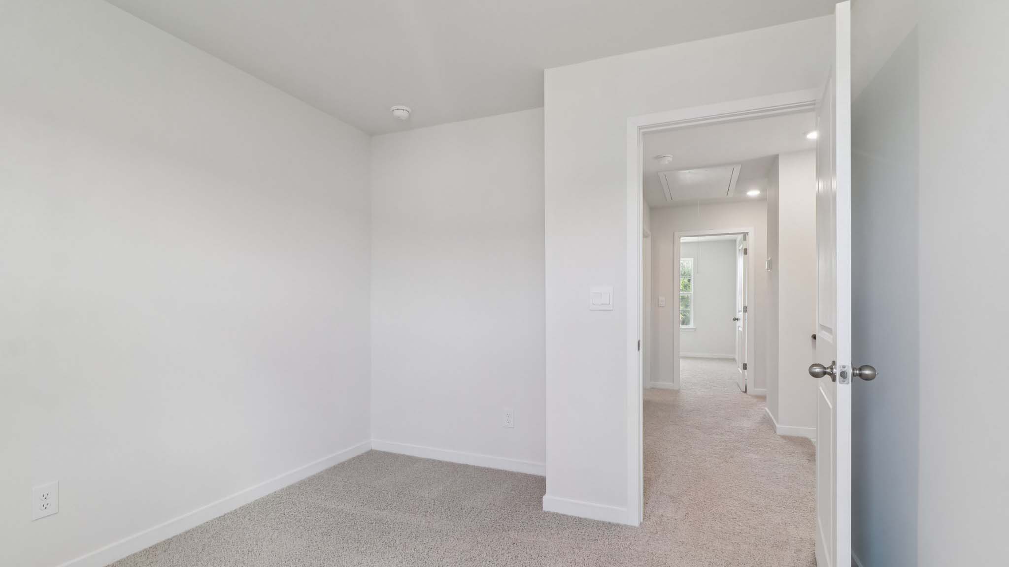Carpeted bedroom with view of hallway