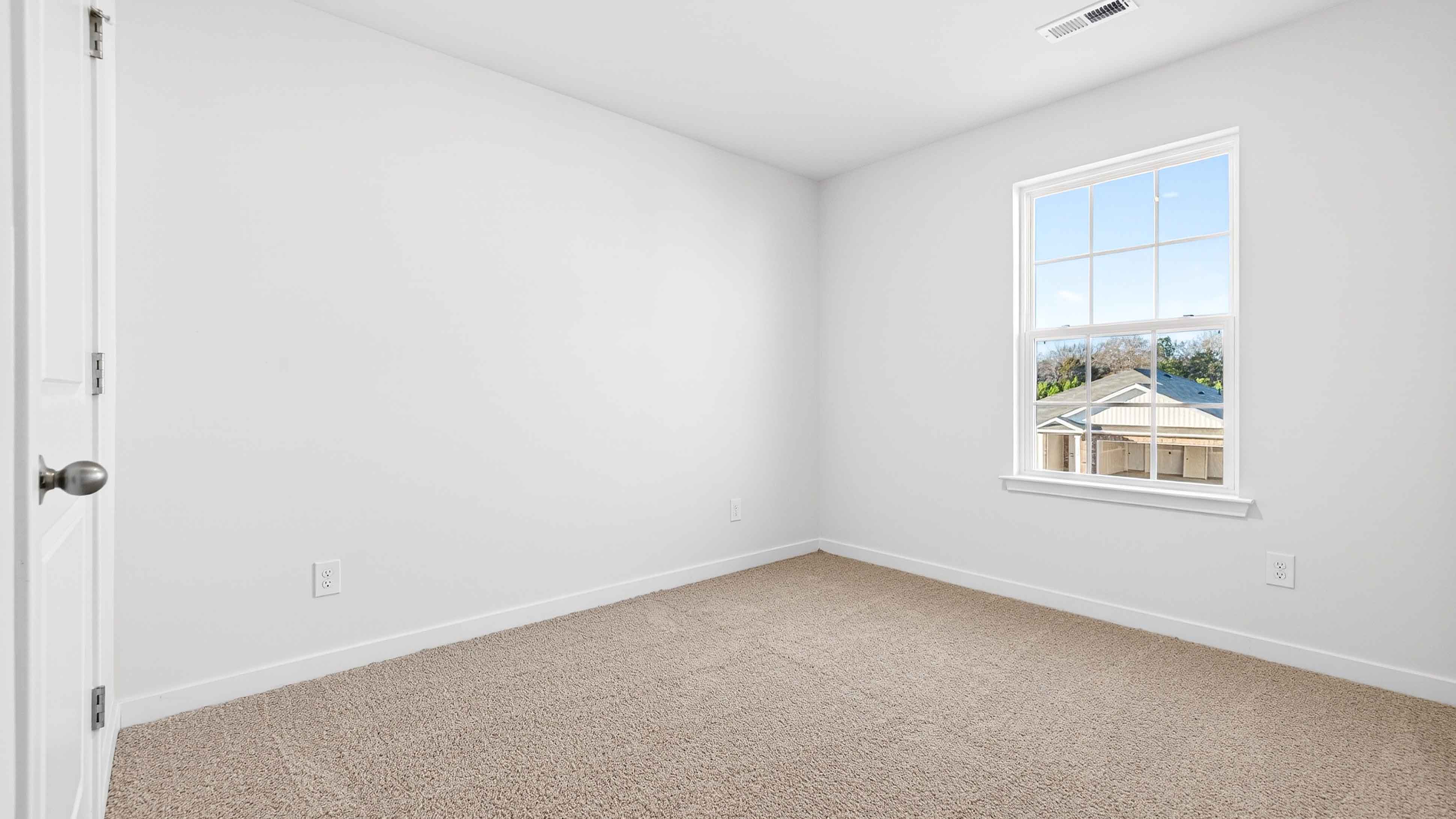 Carpeted bedroom with large window