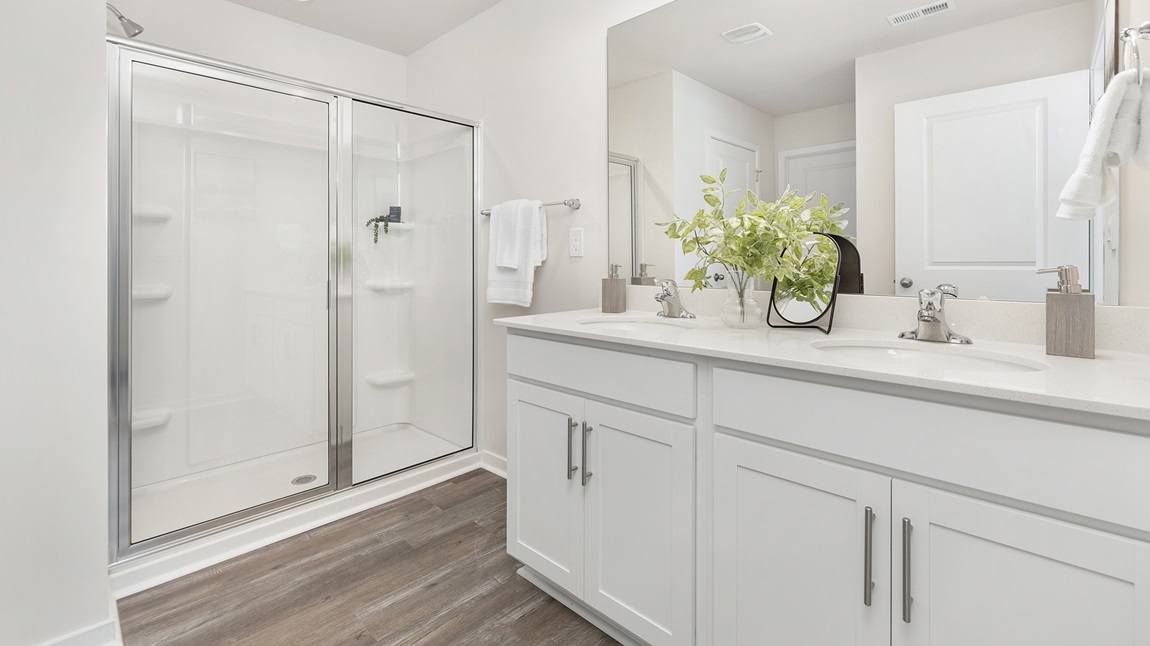 Primary bedroom with dual vanity with walk in shower