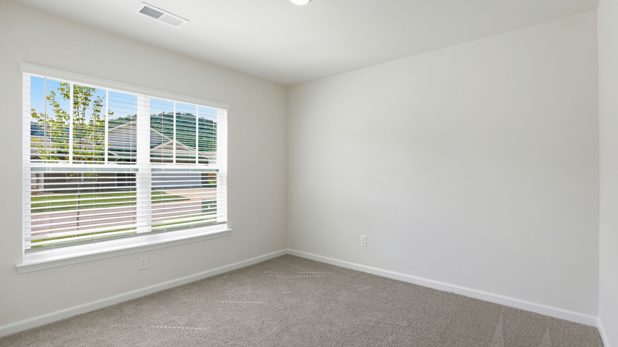Carpeted bedroom with large windows