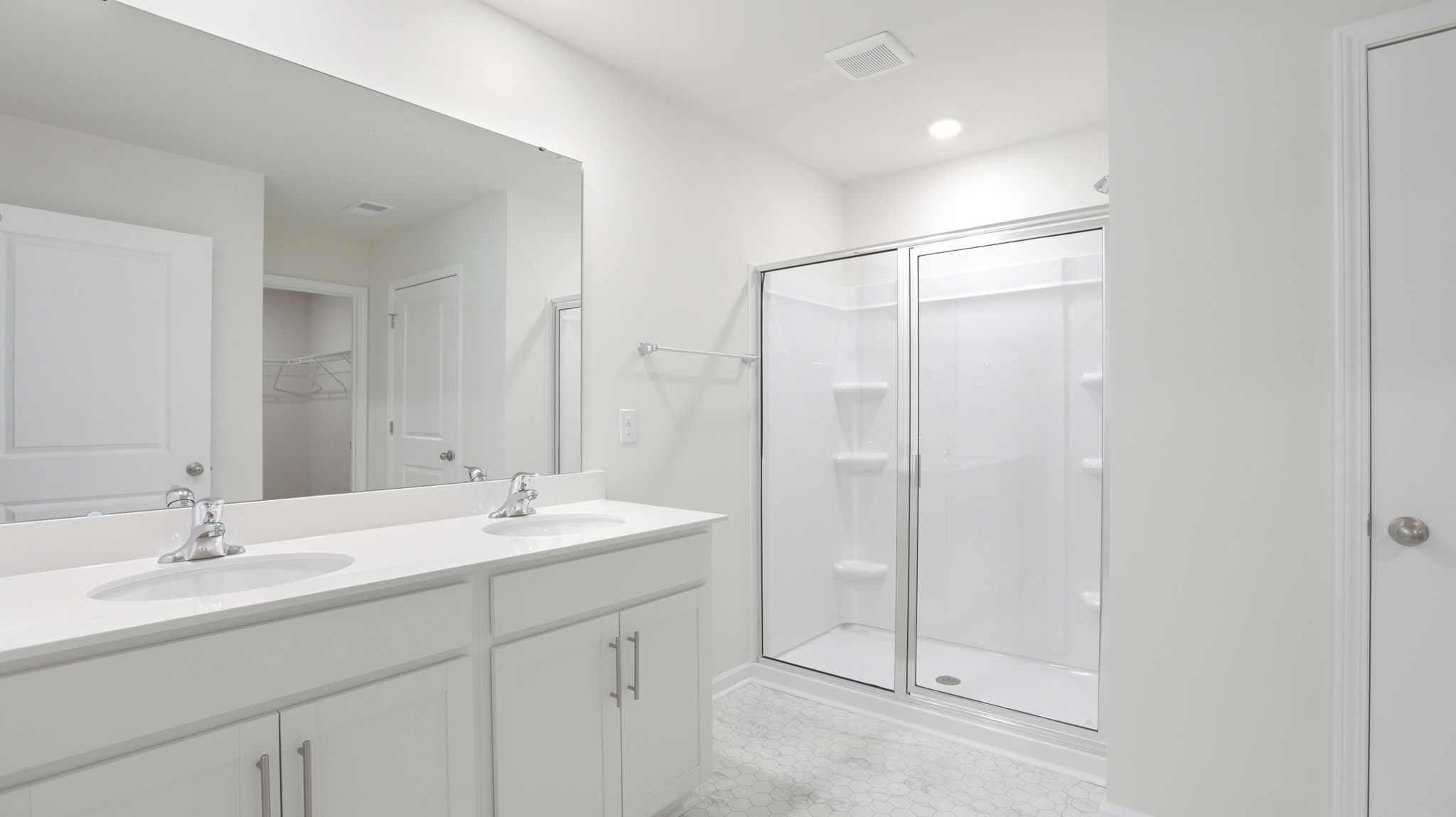Primary bathroom with dual vanity and walk in shower