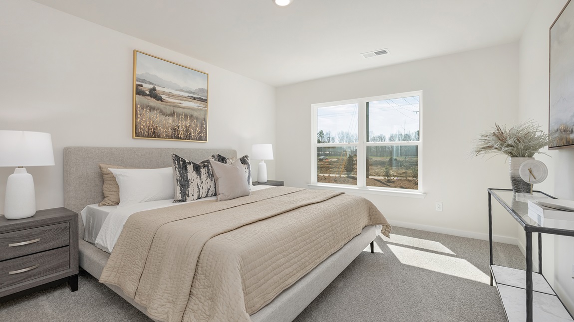 Carpeted primary bedroom with large windows
