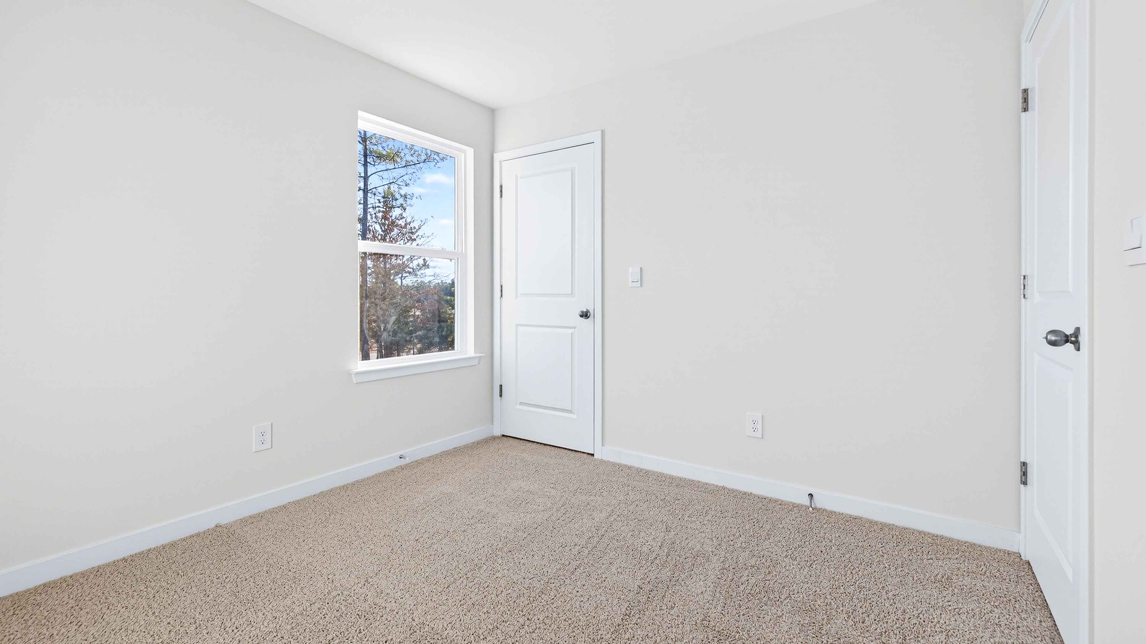 Carpeted bedroom with large window