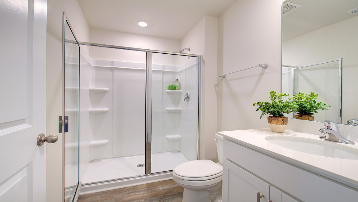 bathroom with dual vanity and walk in shower