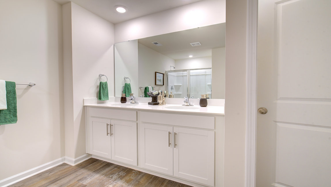 bathroom with dual vanity and walk in shower
