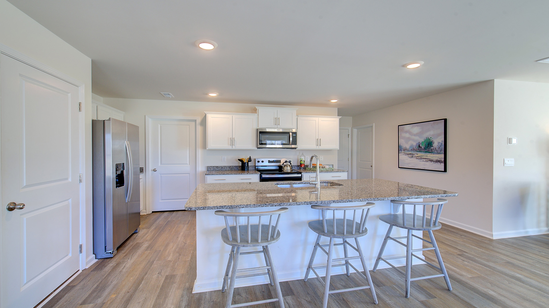 Open concept kitchen with stainless steel appliances and large island