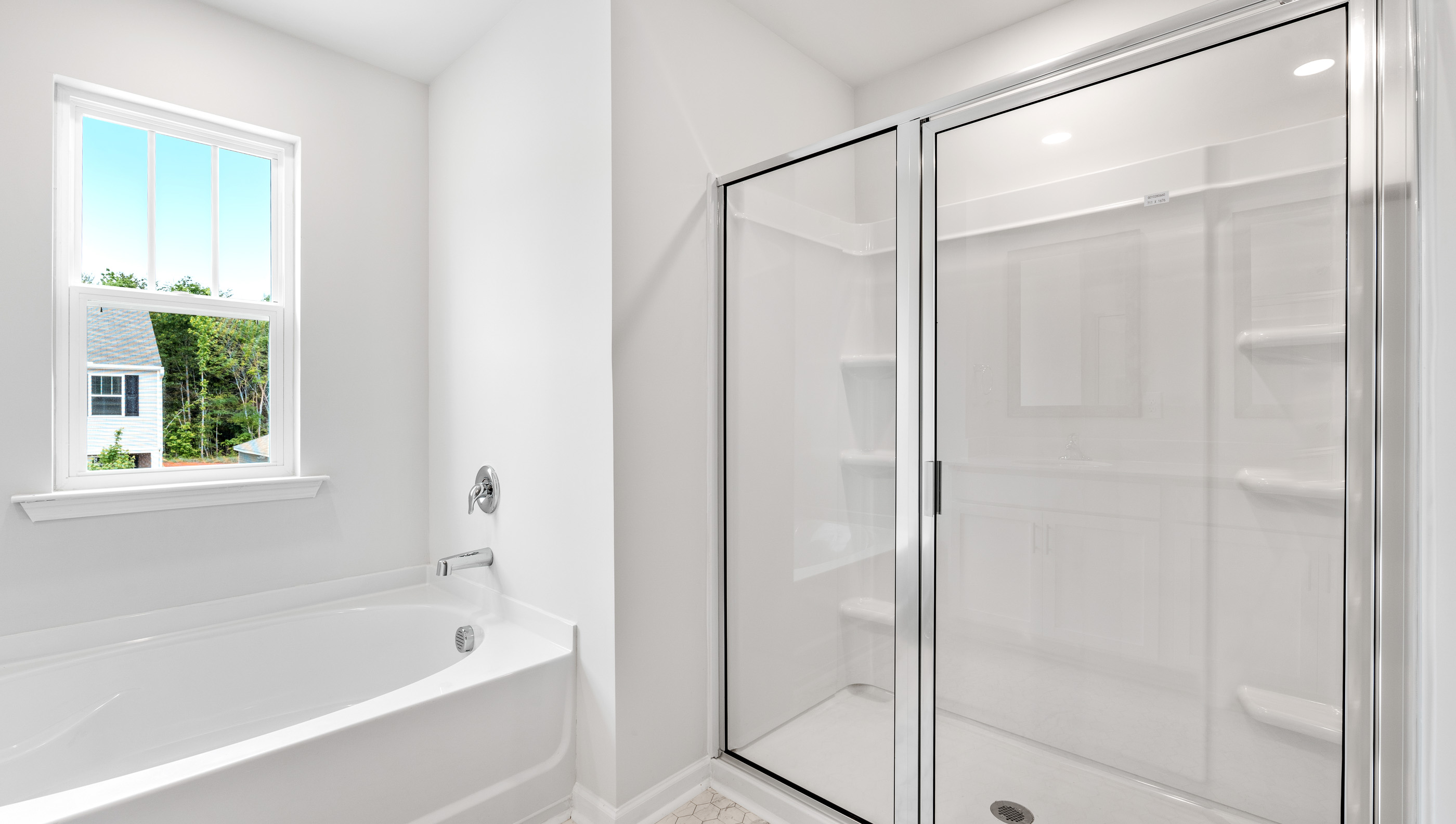 Primary bathroom with dual vanity and walk in shower with glass doors