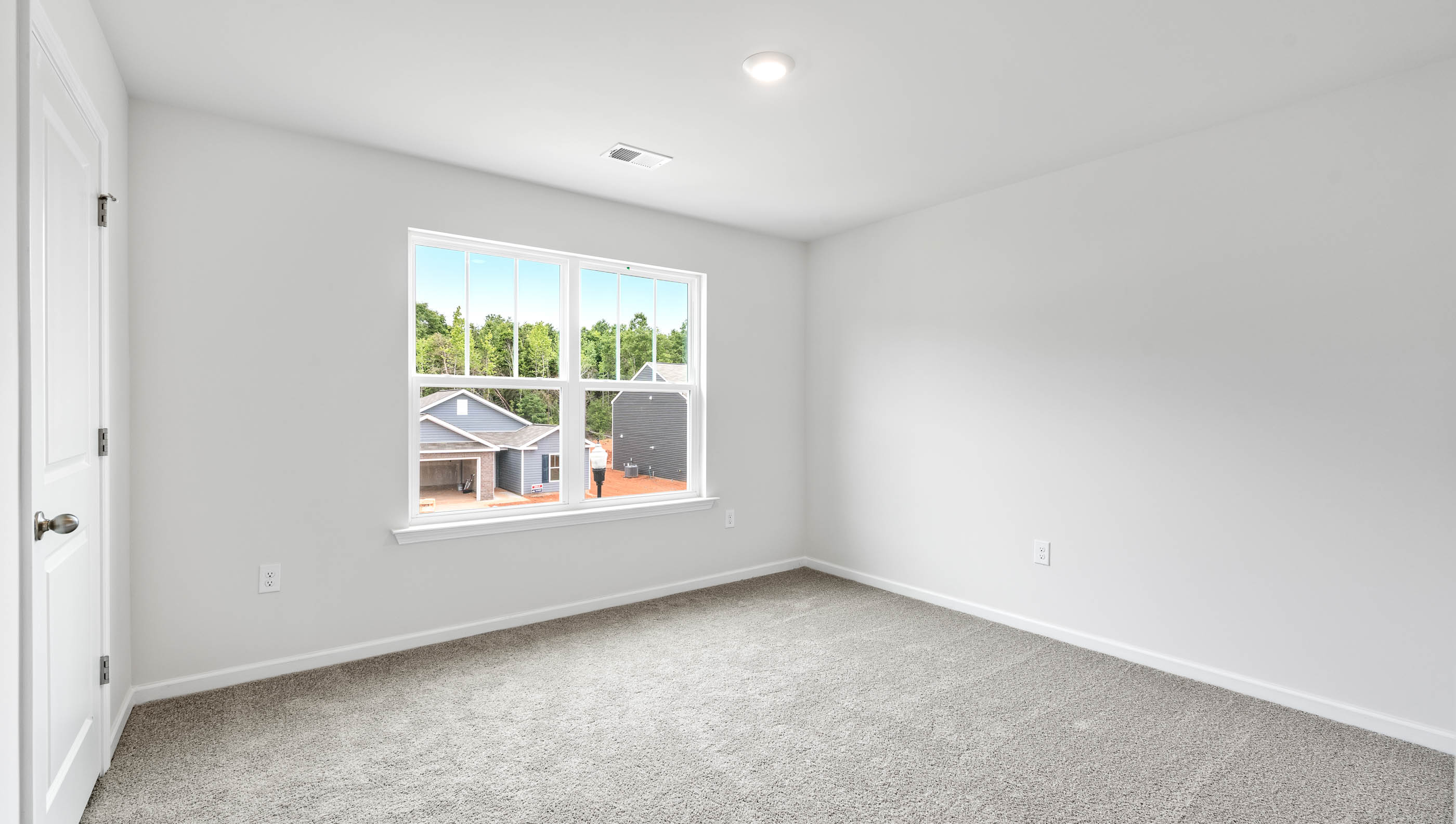 Carpeted bedroom with large window
