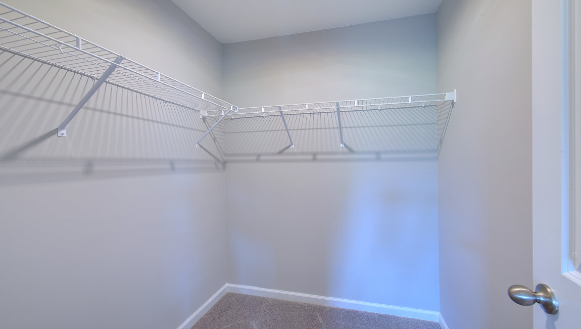 Primary walk in closet with shelving
