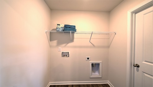 laundry room with built in hanger racks above machine space
