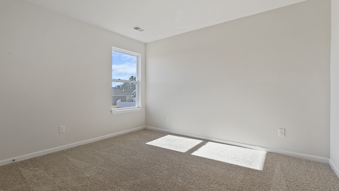 Carpeted bedroom with small window