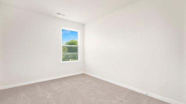 Carpeted bedroom with view of entryway and closet doors